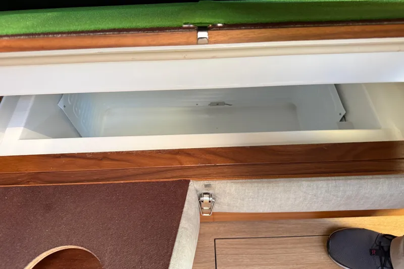 Slide: The Image of Open storage compartment in 2020 Amel 50 yacht interior, featuring wooden and fabric finishes. - 26