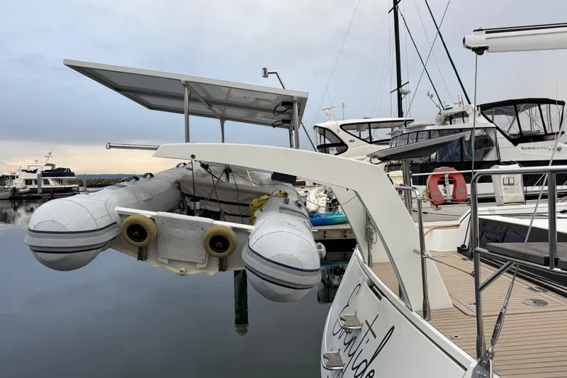 Slide: The Image of 2020 Amel 50 yacht with dinghy and solar panels in marina. - 35