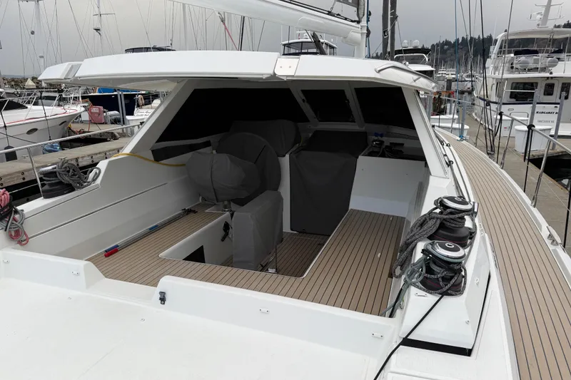 Slide: The Image of 2020 Amel 50 yacht cockpit with covered seating, docked at marina. - 37
