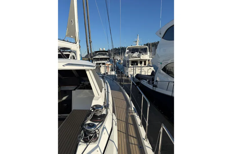 Slide: The Image of 2020 Amel 50 yacht docked among other boats in a marina. - 61