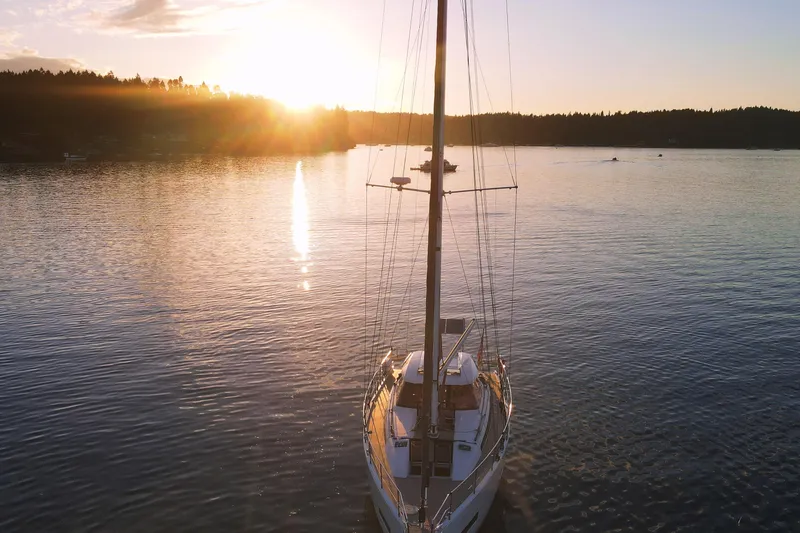 Slide: The Image of Sailboat Amel 50, 2020 model, on tranquil water at sunset. - 66