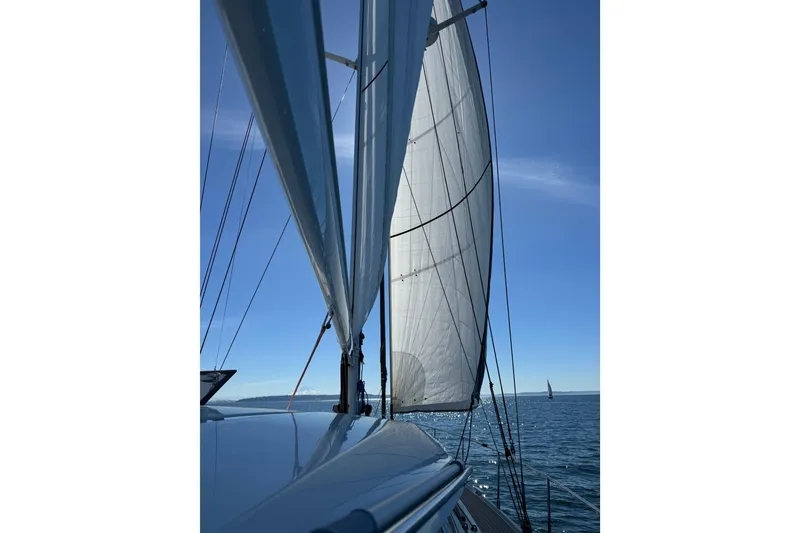 Slide: The Image of Sailing on a 2020 Amel 50 yacht with full sails under a clear blue sky. - 69