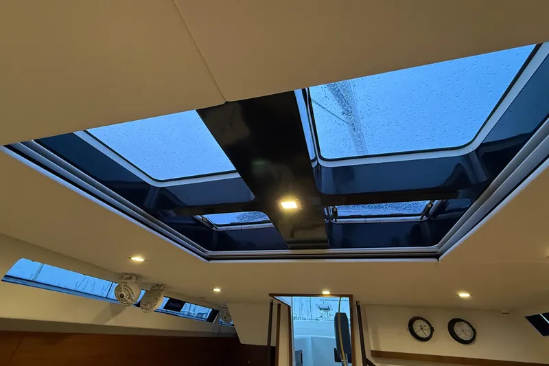Slide: The Image of Interior view of 2020 Amel 50 yacht skylight with raindrops and modern lighting. - 8