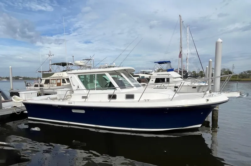 The Image of 2005 Albin 31 Tournament Express boat docked at marina, blue hull, white cabin. - 0