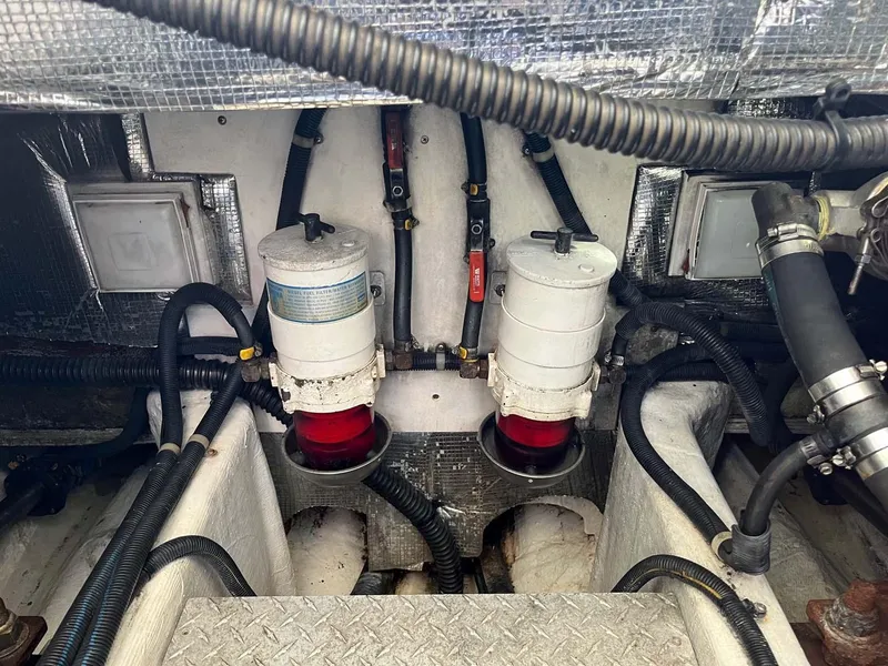 Slide: The Image of Engine compartment of a 2005 Albin 31 Tournament Express boat, showing fuel filters and hoses. - 18