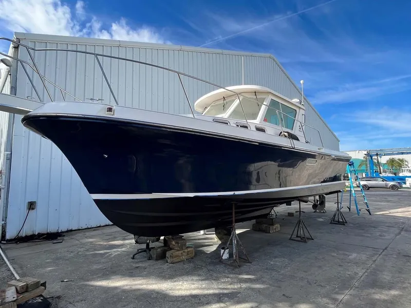 Slide: The Image of 2005 Albin 31 Tournament Express boat on dry dock, blue hull, white cabin, clear sky background. - 22