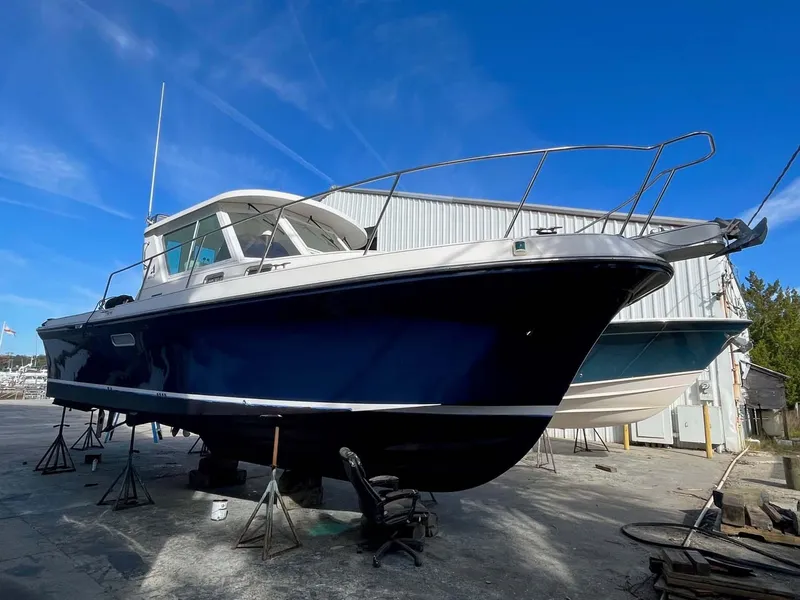 Slide: The Image of 2005 Albin 31 Tournament Express boat on dry dock, blue hull, clear sky background. - 24