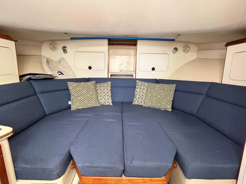Slide: The Image of Interior of 2005 Albin 31 Tournament Express with blue cushioned seating and decorative pillows. - 5
