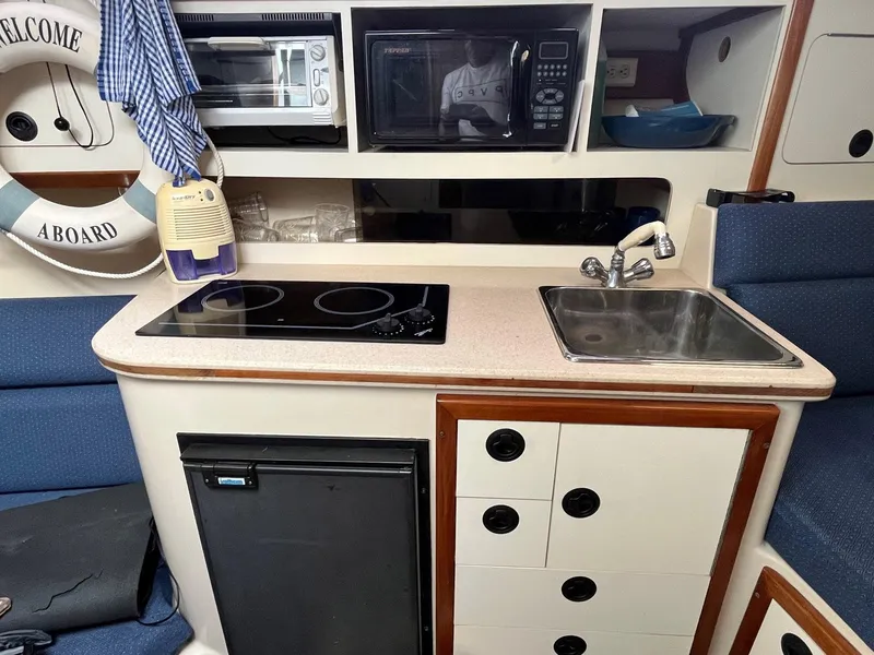 Slide: The Image of Compact kitchen in 2005 Albin 31 Tournament Express boat with stove, sink, and microwave. - 7