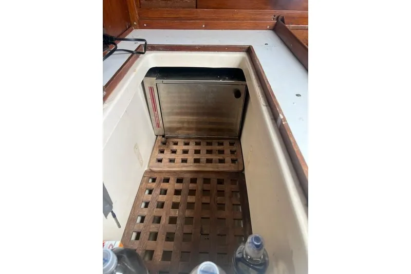 Slide: The Image of 1977 Tartan 37 interior with wooden lattice flooring and built-in storage compartment. - 16