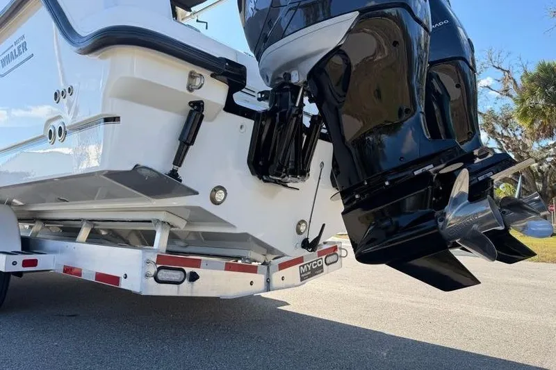 Slide: The Image of 2017 Boston Whaler 285 Conquest boat on trailer with dual outboard engines. - 10