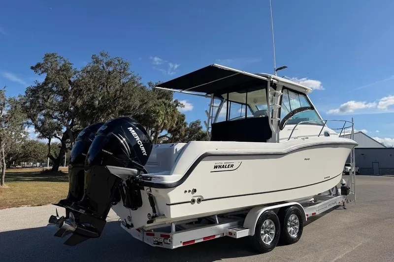Slide: The Image of 2017 Boston Whaler 285 Conquest boat on trailer, featuring twin Mercury engines. - 14