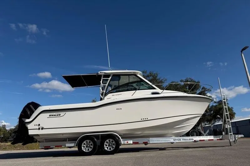 Slide: The Image of 2017 Boston Whaler 285 Conquest boat on trailer under clear blue sky. - 15