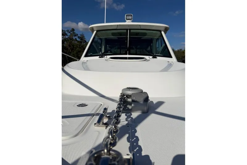 Slide: The Image of 2017 Boston Whaler 285 Conquest boat deck with anchor chain, clear sky background. - 16