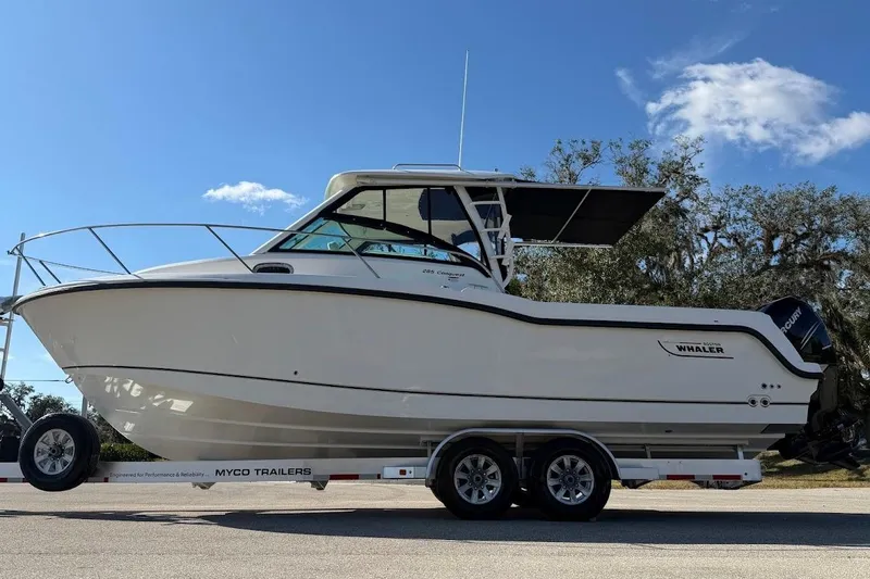 Slide: The Image of 2017 Boston Whaler 285 Conquest boat on trailer under clear blue sky. - 18