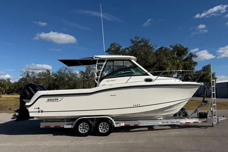 Slide: The Image of 2017 Boston Whaler 285 Conquest boat on trailer under clear blue sky. - 2