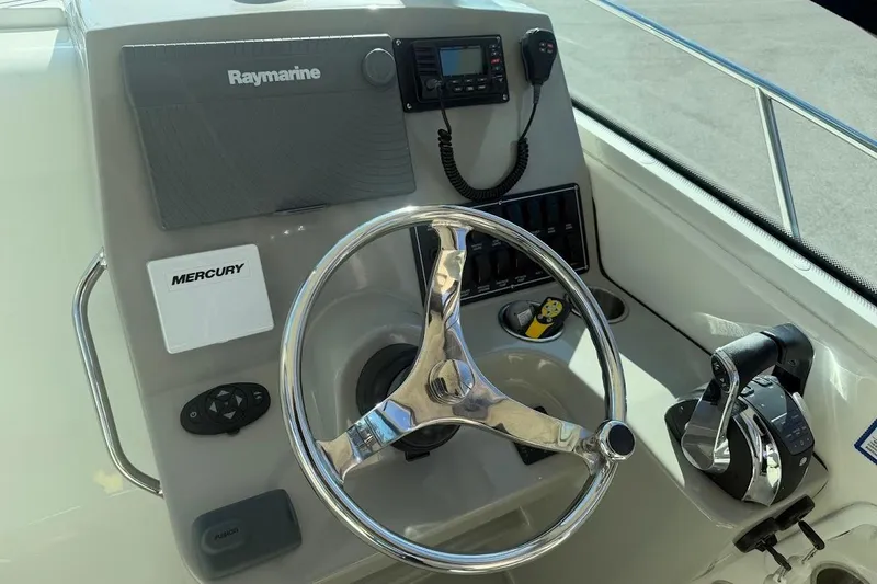 Slide: The Image of Control panel of a 2017 Boston Whaler 285 Conquest boat with steering wheel and navigation equipment. - 29