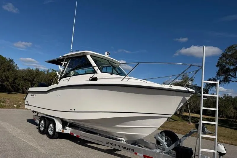 Slide: The Image of 2017 Boston Whaler 285 Conquest boat on trailer under clear blue sky. - 3