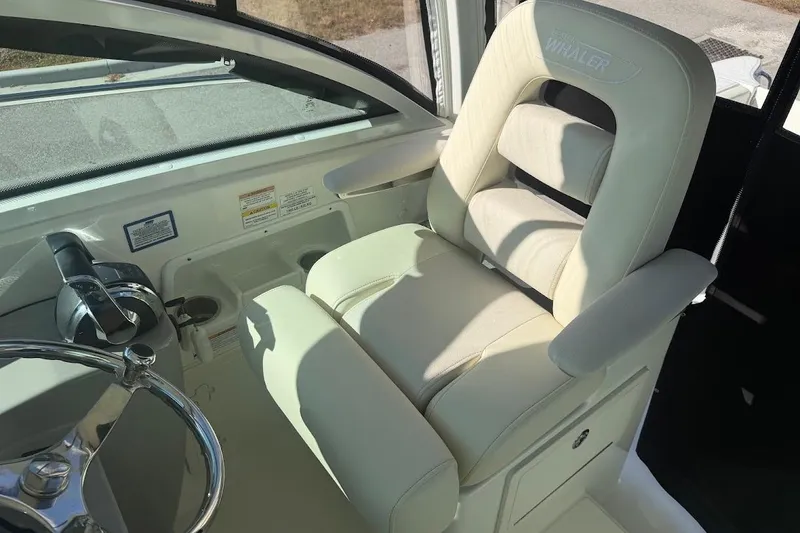 Slide: The Image of 2017 Boston Whaler 285 Conquest helm seat with steering wheel and controls. - 32