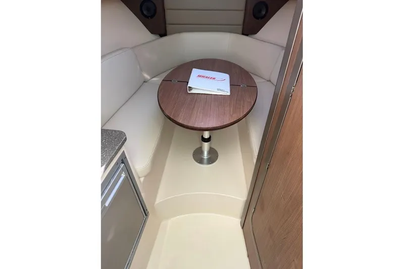 Slide: The Image of 2017 Boston Whaler 285 Conquest cabin interior with table and seating area. - 33