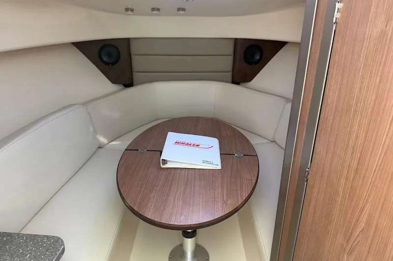 Slide: The Image of Interior of 2017 Boston Whaler 285 Conquest with cozy seating and wooden table. - 36