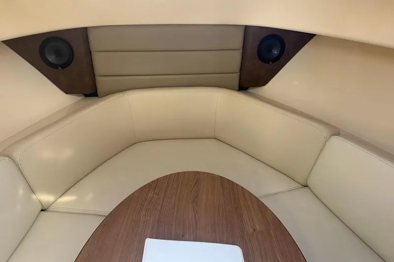 Slide: The Image of 2017 Boston Whaler 285 Conquest cabin interior with beige seating and wood table. - 38