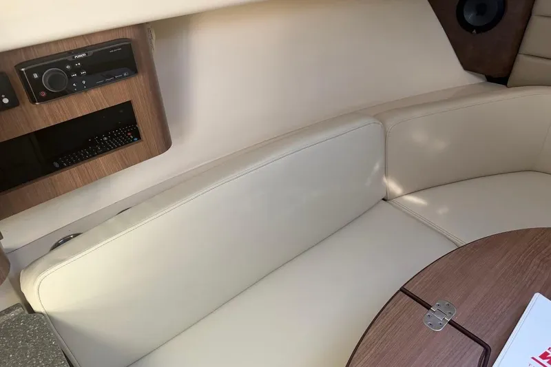 Slide: The Image of Interior of 2017 Boston Whaler 285 Conquest with beige seating and wooden table. - 39