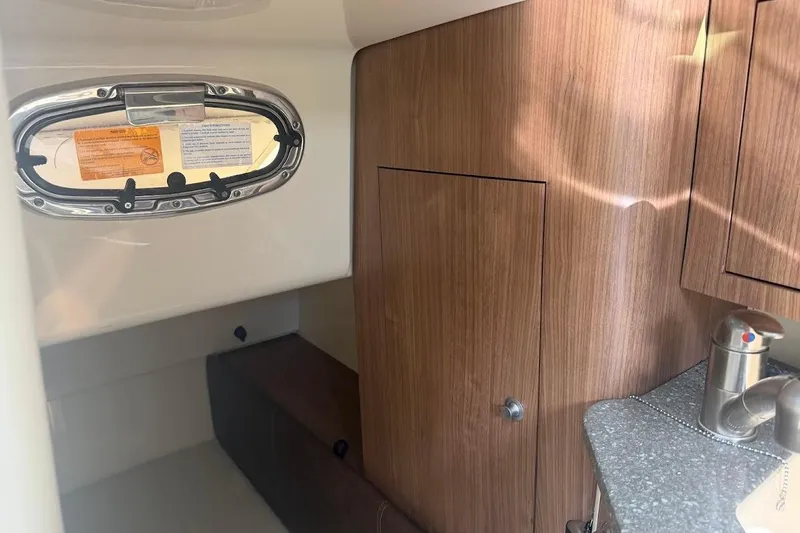 Slide: The Image of 2017 Boston Whaler 285 Conquest cabin interior with wood paneling and porthole window. - 42