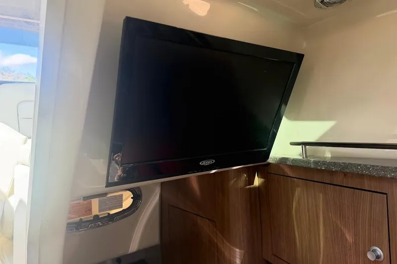 Slide: The Image of Interior of 2017 Boston Whaler 285 Conquest with mounted TV and wooden cabinetry. - 45
