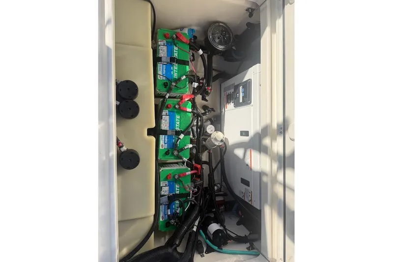 Slide: The Image of 2017 Boston Whaler 285 Conquest battery compartment with multiple batteries and wiring. - 49