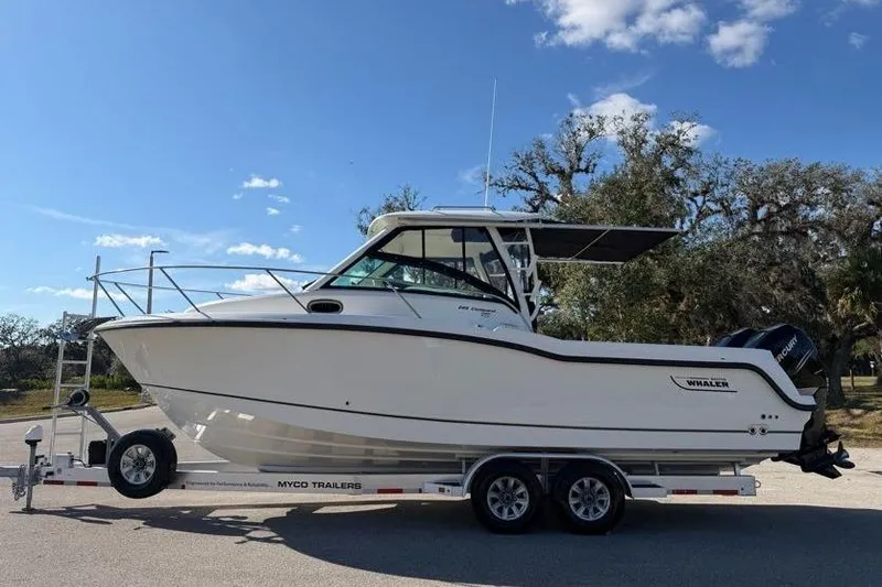 Slide: The Image of 2017 Boston Whaler 285 Conquest boat on trailer under clear sky. - 7