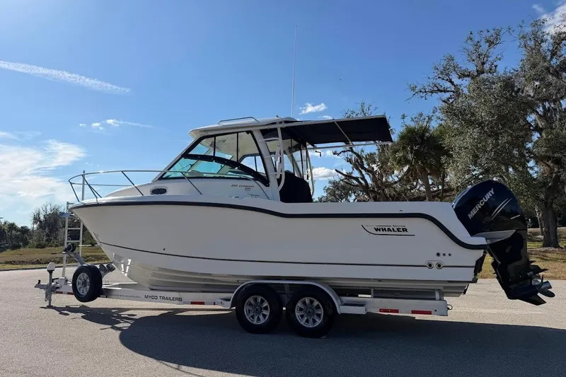 Slide: The Image of 2017 Boston Whaler 285 Conquest boat on trailer under clear blue sky. - 9