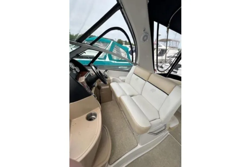 Slide: The Image of 2007 Four Winns 338 Vista boat interior with beige seating and steering area. - 11