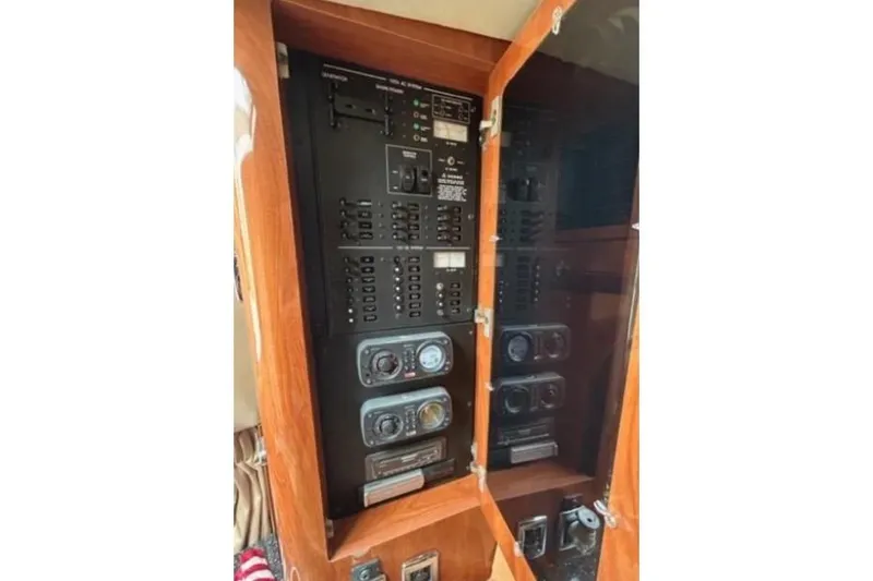 Slide: The Image of Electrical panel inside 2007 Four Winns 338 Vista boat, featuring switches and gauges. - 15