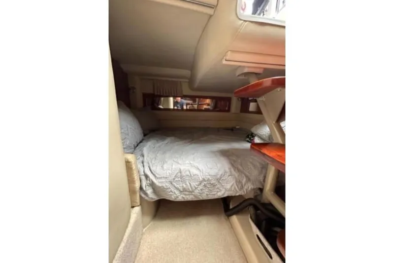 Slide: The Image of 2007 Four Winns 338 Vista cabin interior with cozy bed and wooden accents. - 16