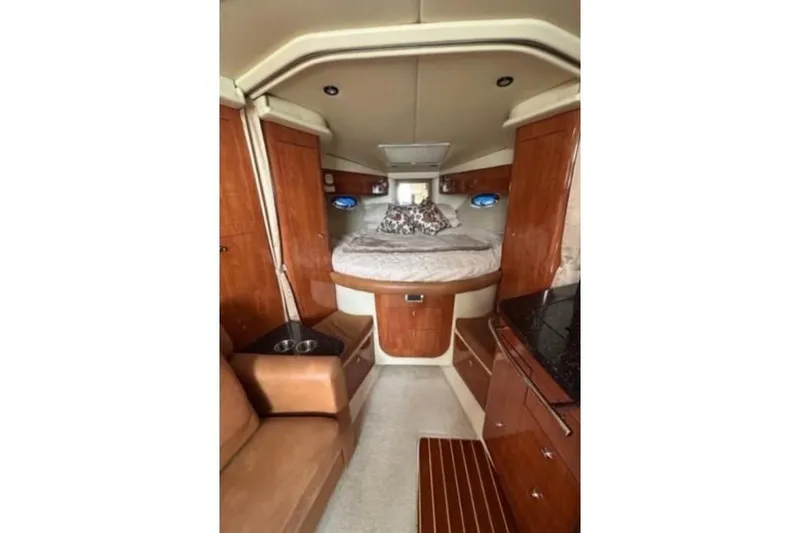 Slide: The Image of 2007 Four Winns 338 Vista cabin interior with bed, wood cabinetry, and seating area. - 17