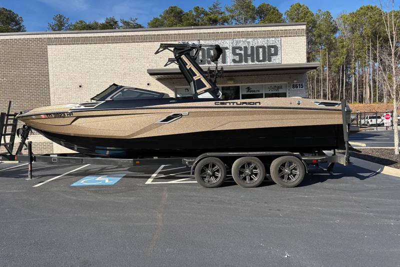 The Image of 2022 Centurion Ri265 boat on trailer outside a shop, parked in a lot. - 1