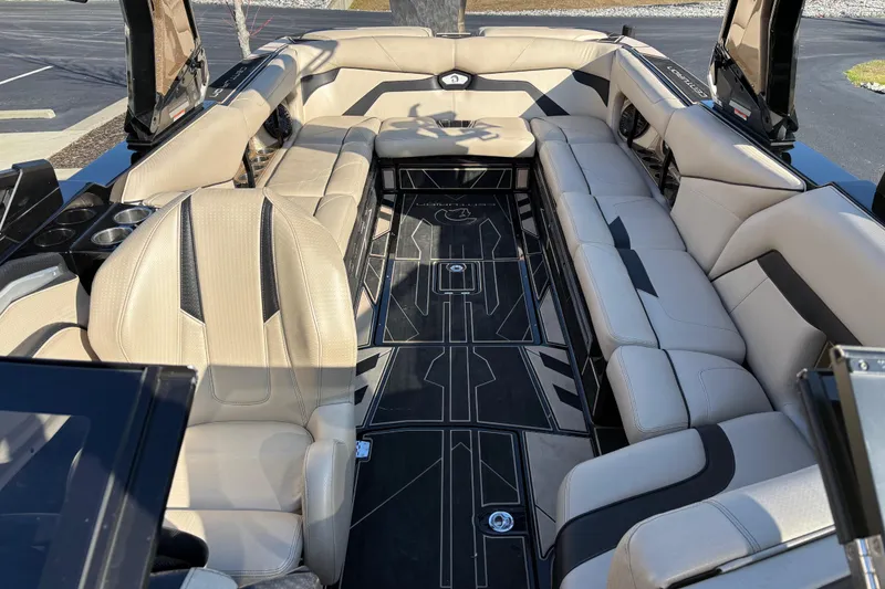 Slide: The Image of 2022 Centurion Ri265 boat interior with luxurious beige seating and sleek black flooring. - 7