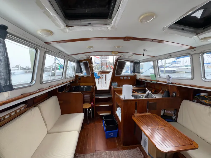 Slide: The Image of Interior of a 1977 Islander Yachts Freeport 36 with wooden furnishings and windows. - 16
