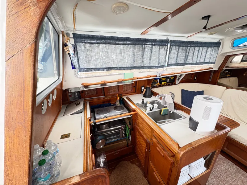 Slide: The Image of Interior of 1977 Islander Yachts Freeport 36, featuring kitchen and seating area. - 3