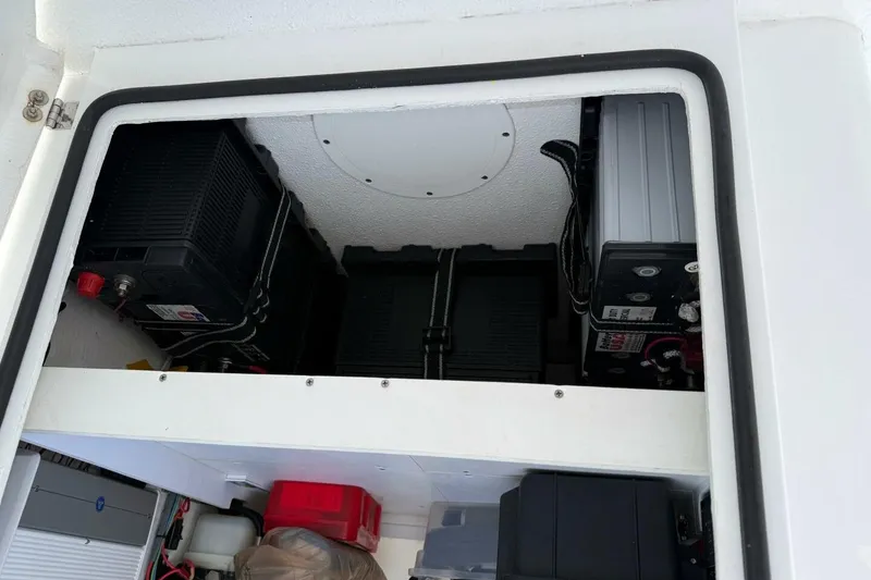 Slide: The Image of 2023 T Craft 27 boat battery compartment with multiple batteries and wiring. - 11