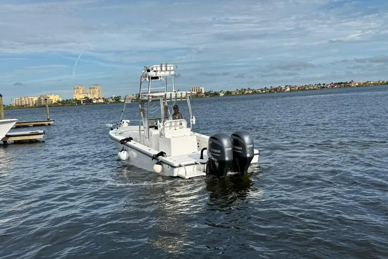 Slide: The Image of 2023 T Craft 27 boat with dual Yamaha engines on a calm waterway. - 22