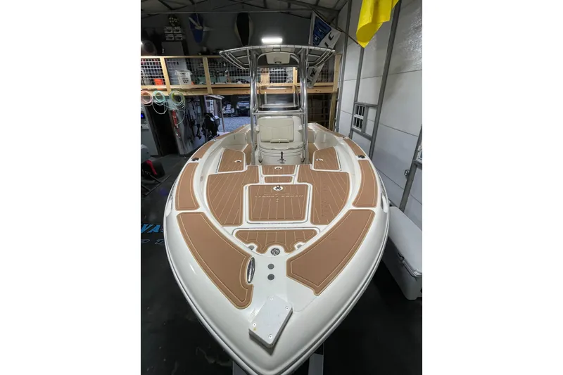 Slide: The Image of 2011 Hydra-Sports Bay Bolt 23 boat in a garage, featuring a sleek deck design. - 18