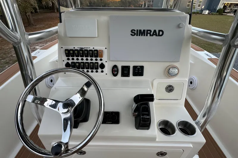 Slide: The Image of 2011 Hydra-Sports Bay Bolt 23 boat console with steering wheel, Simrad display, and control panel. - 23