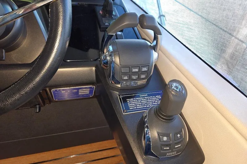 Slide: The Image of 2019 Sunseeker Predator 50 yacht helm controls with steering wheel and throttle levers. - 16