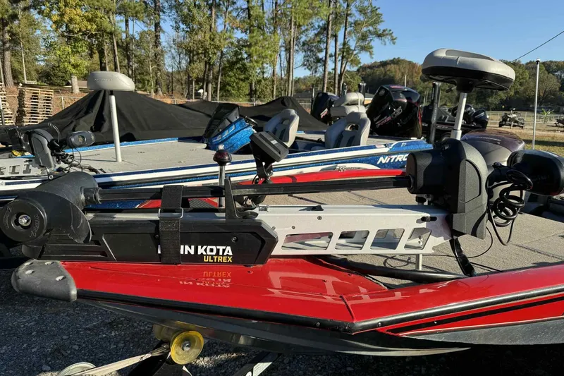Slide: The Image of 2006 Bass Tracker PT190 boat with Minn Kota Ultrex trolling motor, parked outdoors. - 2