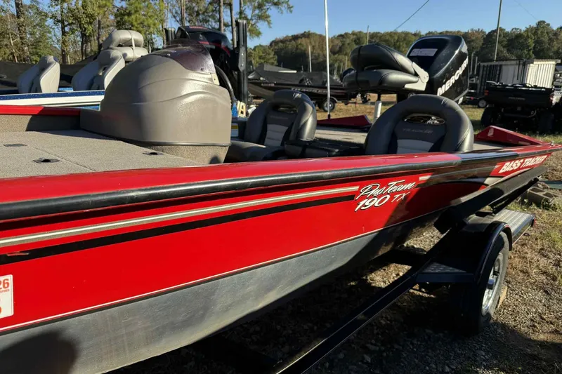 Slide: The Image of 2006 Bass Tracker PT190 boat with red exterior and seating, parked outdoors. - 4