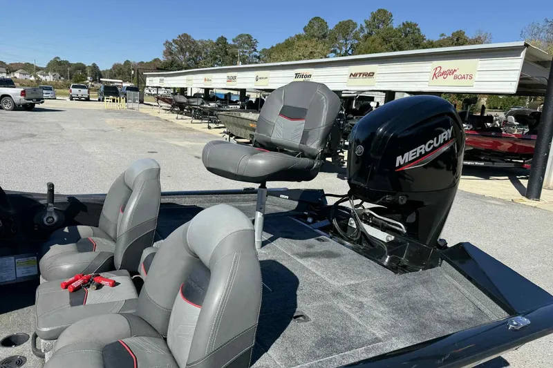 Slide: The Image of 2021 Bass Tracker 190 PT boat with Mercury engine and gray seating, displayed outdoors. - 5
