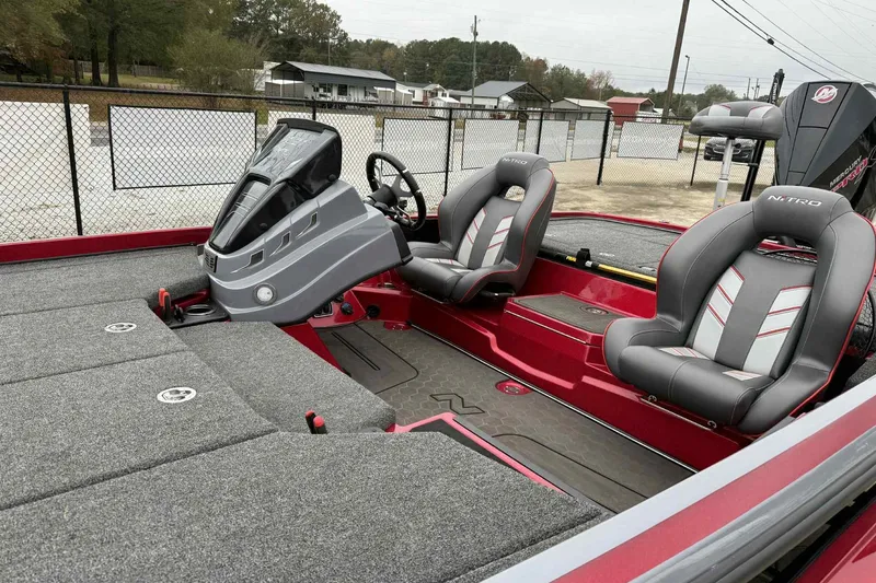 Slide: The Image of 2024 Nitro Z21 XL boat interior with gray and red seating, steering console, and carpeted deck. - 7