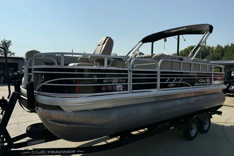 Slide: The Image of 2023 Sun Tracker SportFish 20 DLX pontoon boat on trailer, outdoor setting. - 4
